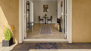 A doorway leading to a room with a dining table, chairs, and a small cabinet.