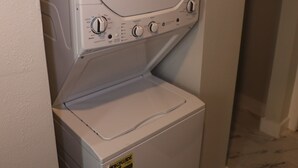 A front-loading washer and dryer unit with a control panel, ENERGY GUIDE label, and a door with a handle. - Cozy 1-bedroom apartment in lovely Dallas with AC (Dallas)