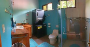 A bathroom with a toilet, sink, shower, and a television. - Spacious Monteverde Bird-watchers Home (Monteverde)
