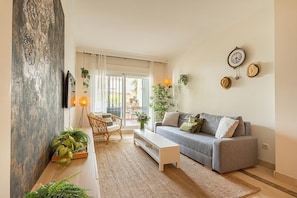 A living room with a grey sofa, a white coffee table, and a large mirror on the wall. - Calanova Grand Golf, La Cala de Mijas, Spain (La Cala de Mijas)