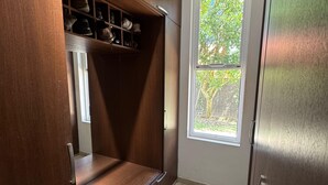 A room with a built-in wooden shelf, a window with a view of greenery, and a door. - Luxury house in Villavicencio, just 10 mins from the city surrounded by nature. (Villavicencio)