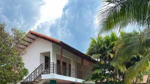 A two-story house with a stone staircase, a swimming pool, and a red lounge chair. - Luxury house in Villavicencio, just 10 mins from the city surrounded by nature. (Villavicencio)