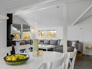 Ein modernes Interieur mit Essbereich, einer Sofagruppe und einer Küchenzeile mit Herd.