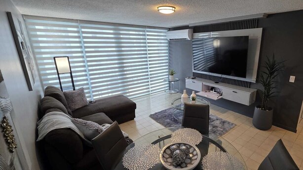Ein modernes Wohnzimmer mit einer Couch, einem Fernseher und Dekorationselementen.