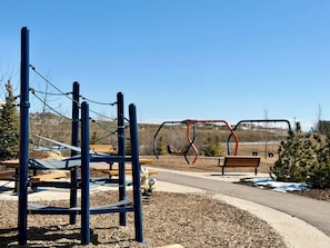 Un parque infantil con estructuras para escalar y columpios.