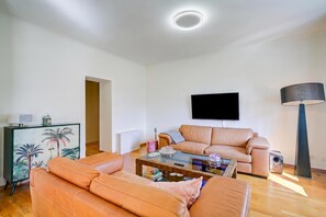 Una sala de estar moderna con un sofá, una mesa de centro y una televisión.