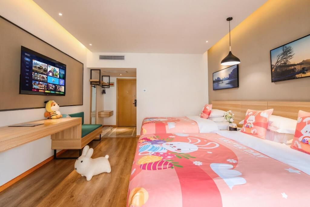 Een moderne hotelkamer met een groot bed, een bureau, een televisie en uitzicht op de omgeving.