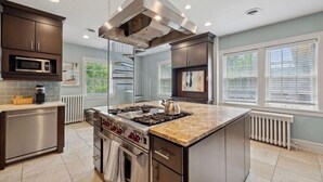 Una cocina moderna con una isla central, electrodomésticos de acero inoxidable y un microondas integrado.