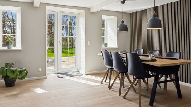 A modern dining area with a wooden table, black chairs, and pendant lighting. - "Farah" - 25km from the sea by Interhome (Skærbæk)