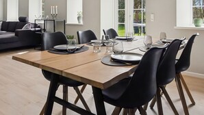 A dining area with a wooden table, black chairs, and pendant lighting. - "Farah" - 25km from the sea by Interhome (Skærbæk)