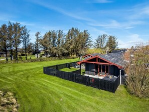 A well-maintained lawn, a small building with a red roof, and a black fence. - "Kiana" - 800m from the sea by Interhome (Hjørring)