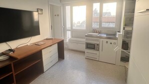 A compact kitchen with a microwave, oven, and sink.