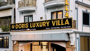 Um edifício com uma placa indicando 'Doris Luxury Villa' e informações de contato.