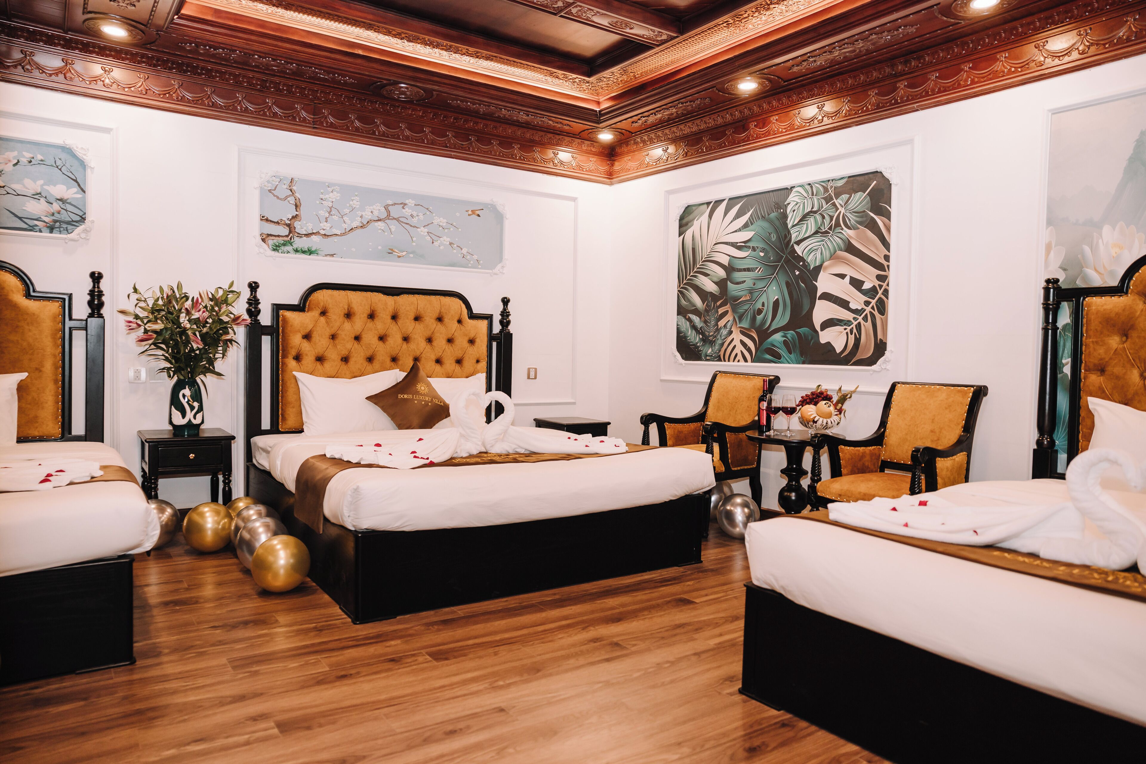 Habitación de hotel con dos camas, piso de madera y obras de arte en las paredes.