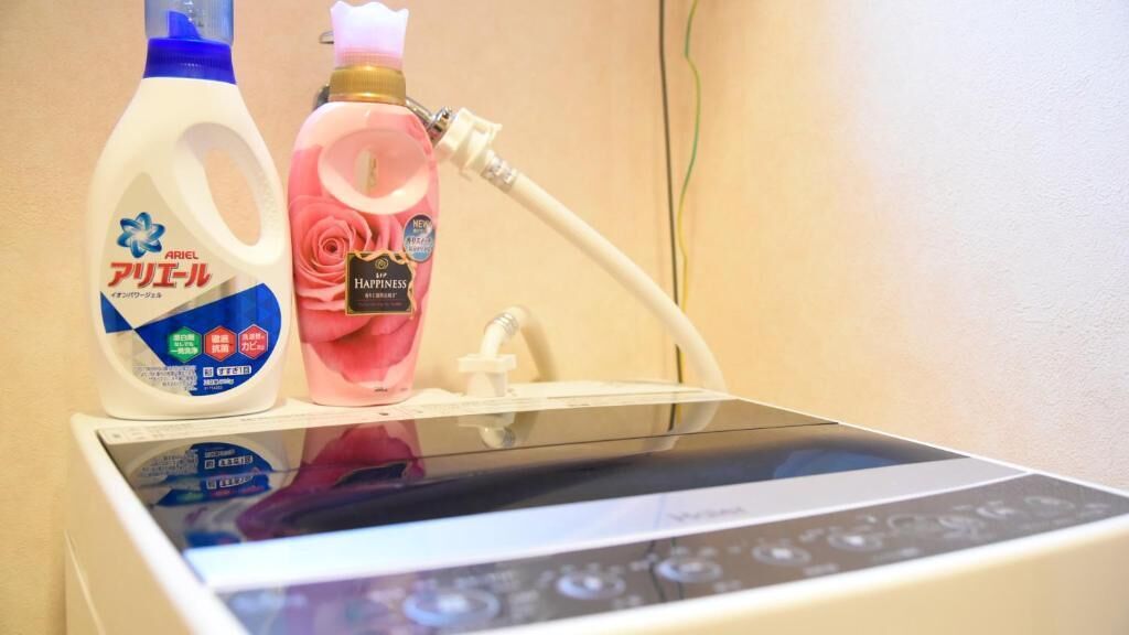 A room with a bed, a bedside table, and a wall-mounted device.