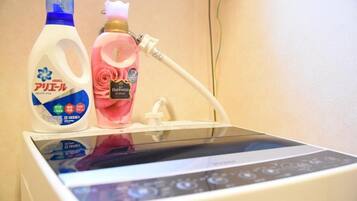 A room with a bed, a bedside table, and a wall-mounted device.