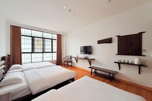 A hotel room with two beds, a desk, a TV, and a window with curtains. - Shengshi Fengqing Boutique Inn (Zhangjiajie)