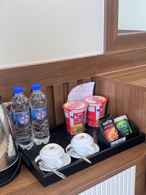 A tray with water bottles, a cup of coffee, a bowl of soup, and a tray of breakfast items including a bagel and a packet of coffee. - Dong A Hotel Pho Co Ninh Binh (Hoa Lu)