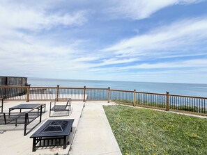 A deck with outdoor furniture, a grassy area, and a view of the ocean. - Lakeview retreat closer to Toronto and Niagara Area (Hamilton)