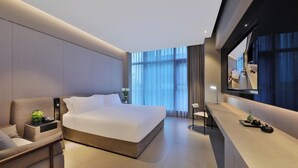 Une chambre d’hôtel moderne, dotée d’un grand lit, d’un bureau et d’un miroir.