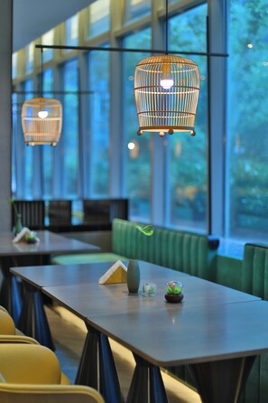 Un intérieur moderne avec des tables, des chaises et des lampes suspendues.