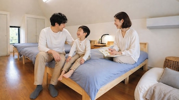 Una habitación con cama, mesita de noche con lámpara y ventana.