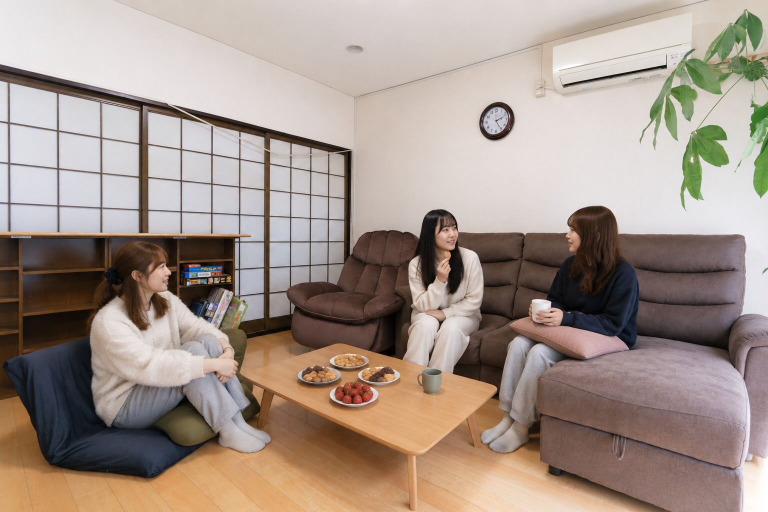 Una habitación con un sofá, una mesita de centro con aperitivos, una estantería y un reloj en la pared.