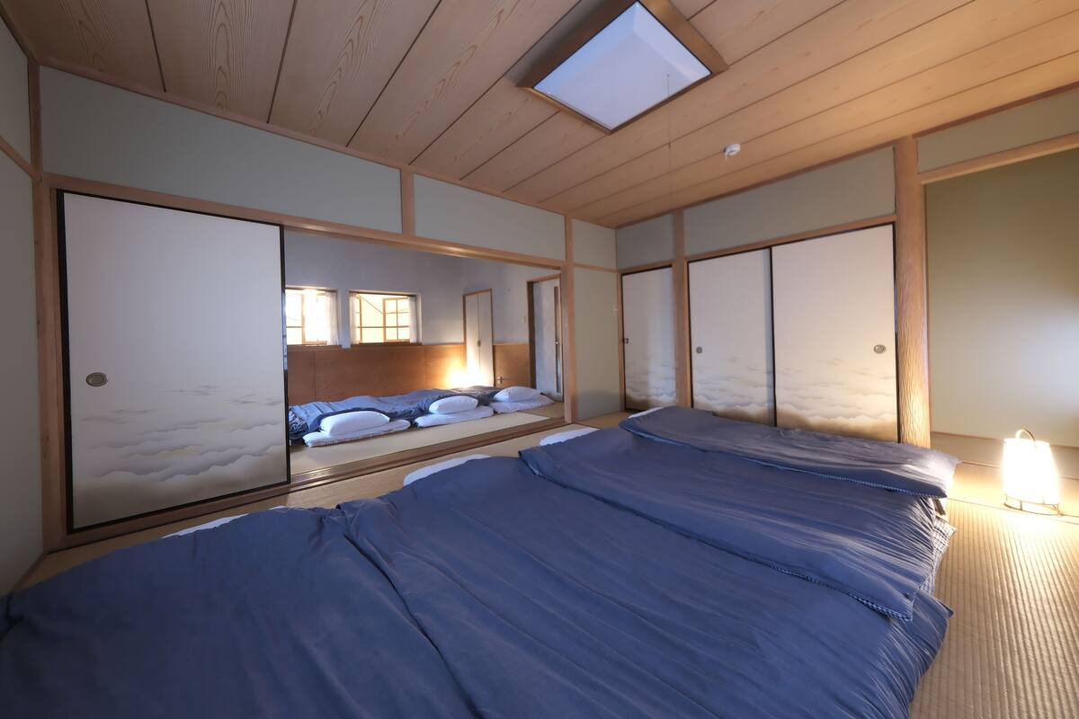 A room with a bed, a window, and sliding doors.
