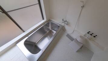 A bathroom with a bathtub, a toilet, and a shower.