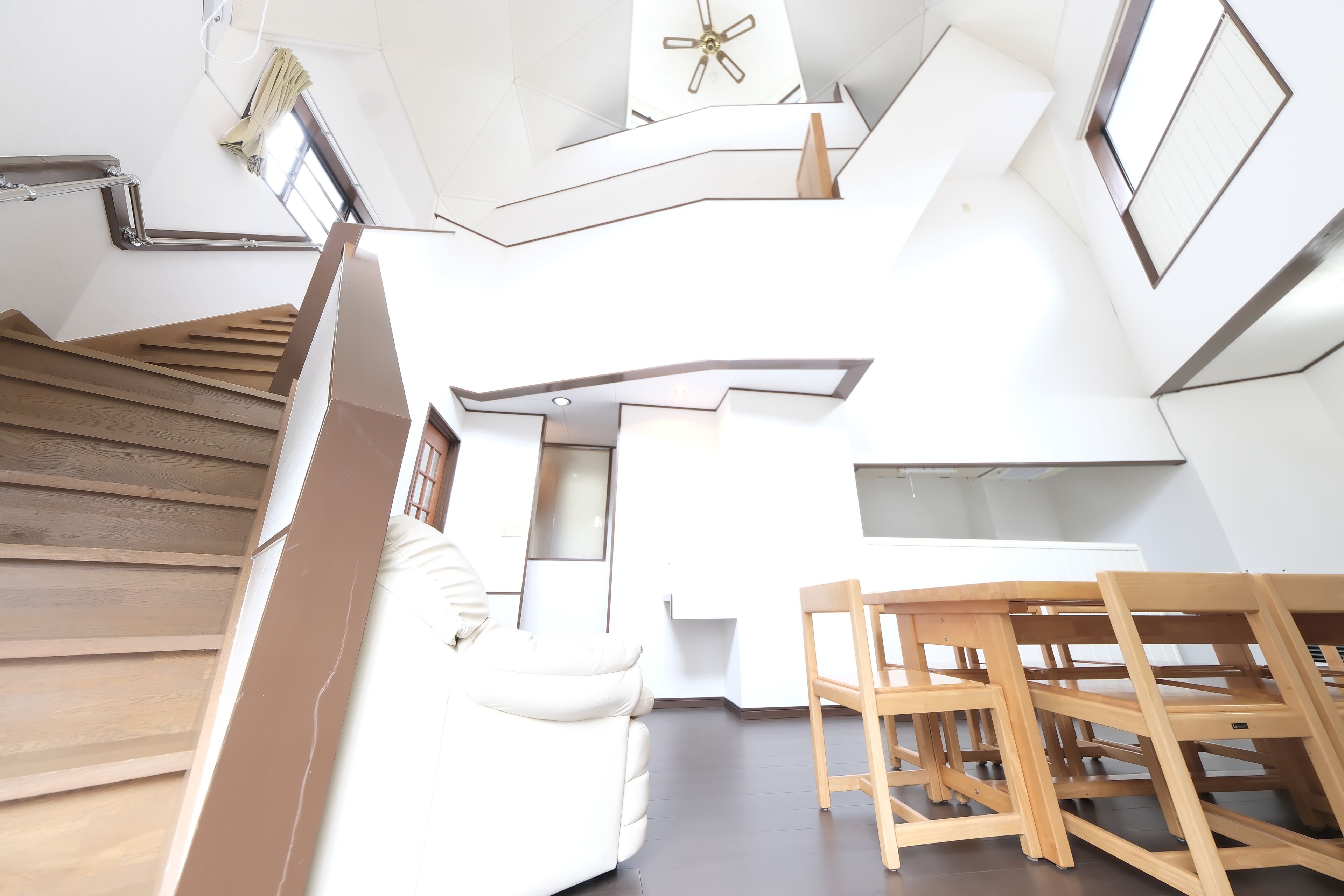 Un interior moderno con una escalera, un comedor y una cocina.