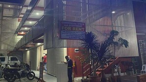Un edificio con un letrero de neón que dice 'Adolfo Residencia'. Hay un anuncio de espacio comercial y apartamentos en alquiler.
