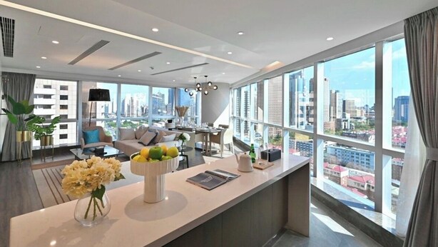 Una habitación de hotel moderna con vistas a la ciudad, un área de comedor y un ventanal grande.