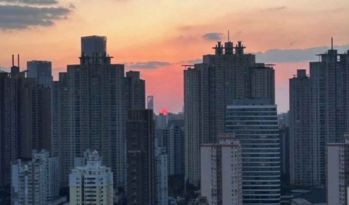 A cityscape with high-rise buildings during sunset.