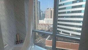 Un baño con un ventanal grande, un perchero y un espejo.
