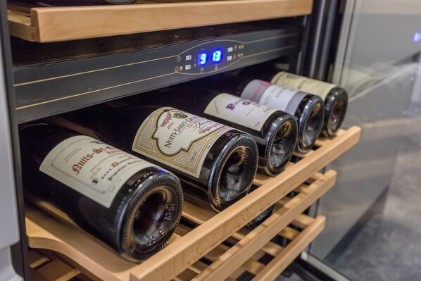 A wine rack with bottles in a refrigerated display case.