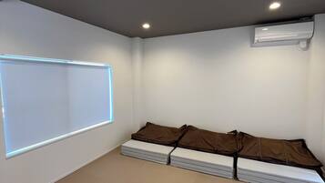 Una habitación con pantalla de proyector, un sofá y un aire acondicionado.