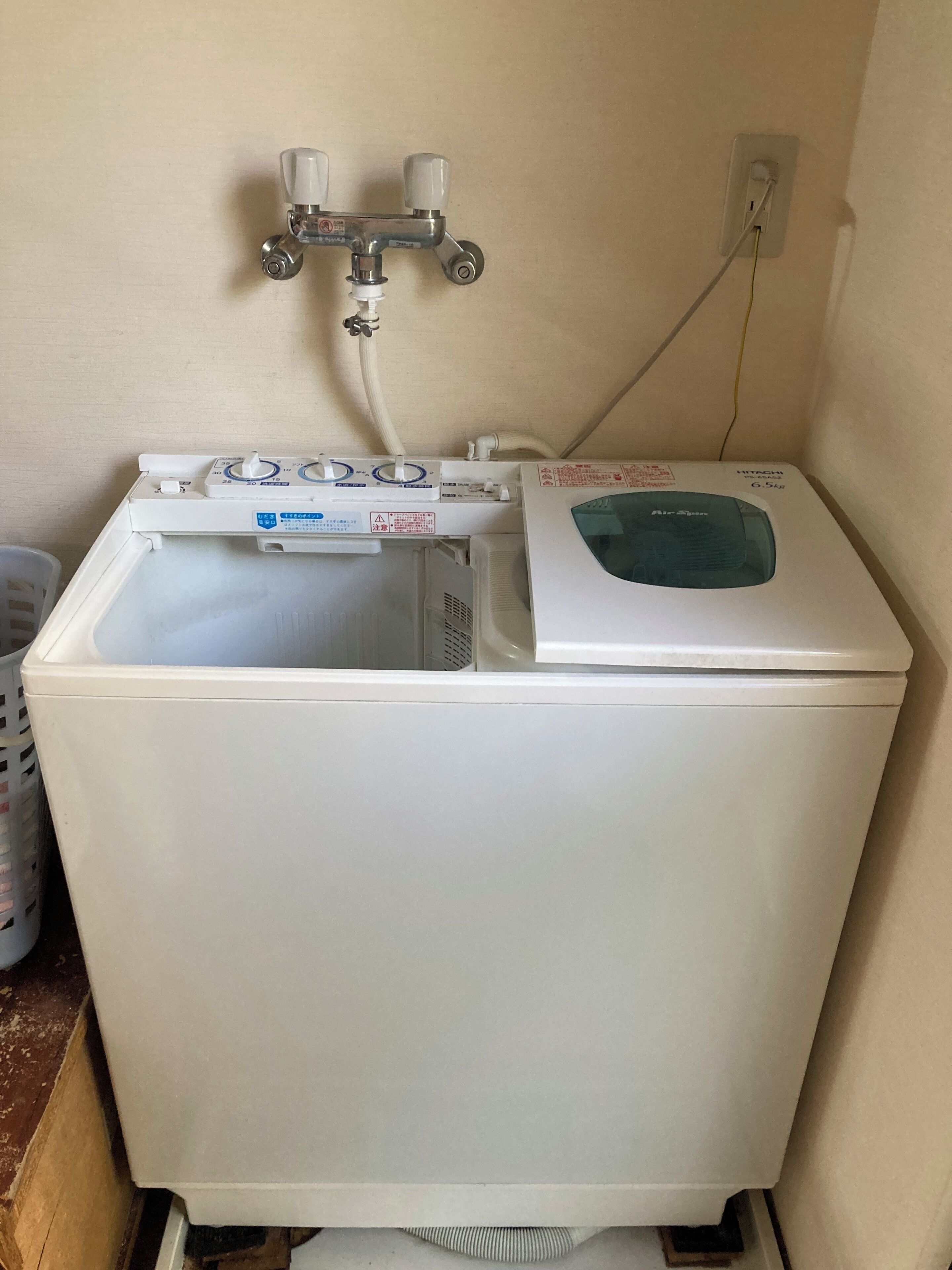 A white washing machine with a control panel and a water inlet.
