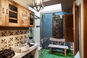 Eine kleine Küche mit Holzausstattung, einem Spülbecken und einer Essecke mit einer Bank.