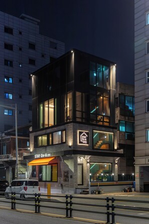 A multi-story building with a 'Stay On A' sign, a visible staircase, and a parked car. - STAY On-A (Seoul)