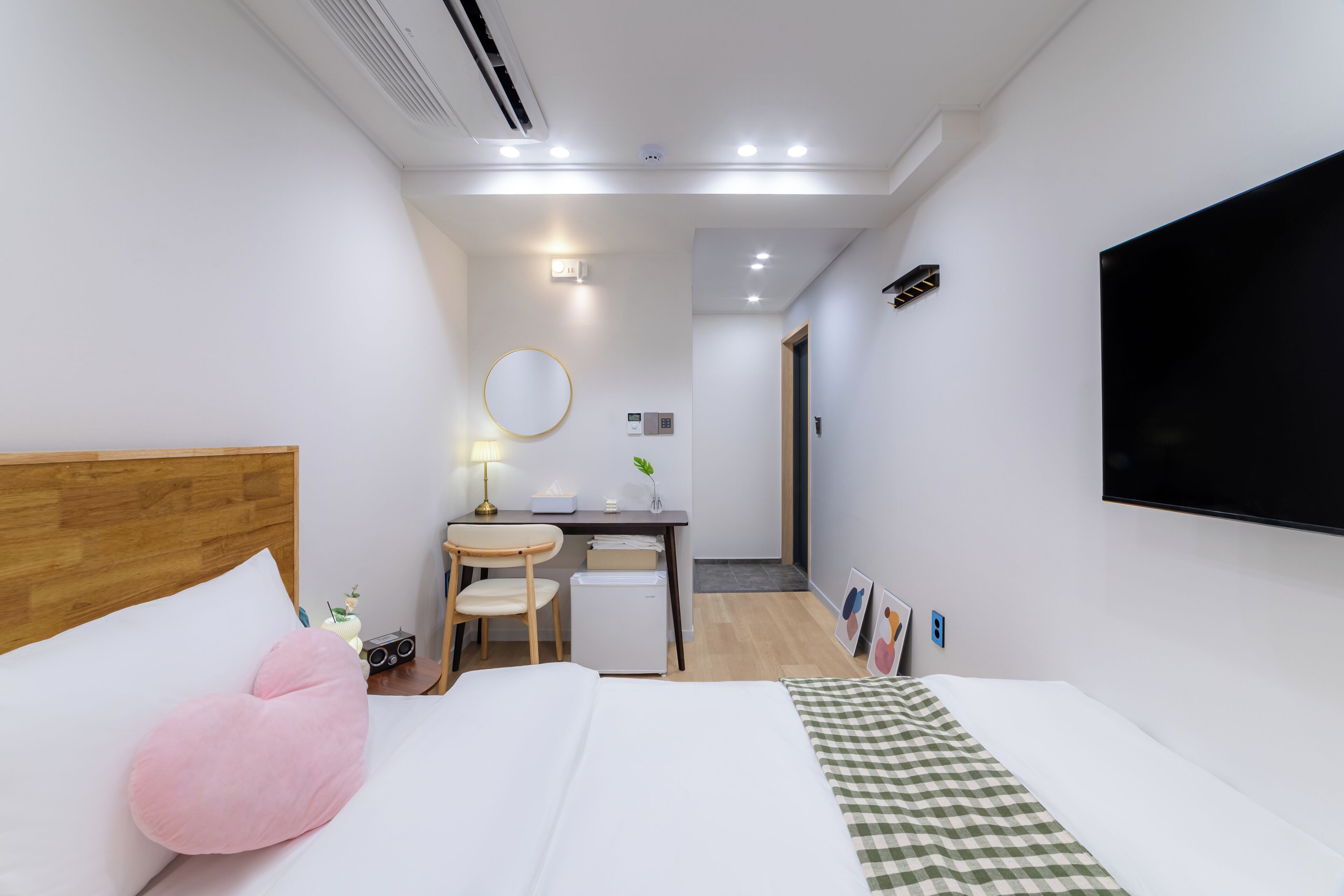 Une chambre d’hôtel équipée d’un lit, d’un bureau, d’une chaise, d’une télévision et d’un petit réfrigérateur.