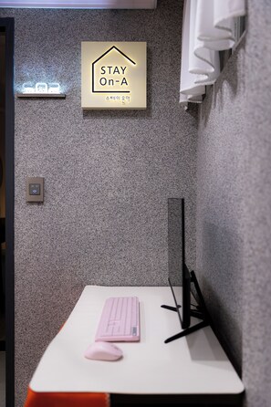 A small workspace with a desk, a keyboard, a mouse, a sign that reads 'STAY On-A,' and a thermostat on the wall. - STAY On-A (Seoul)