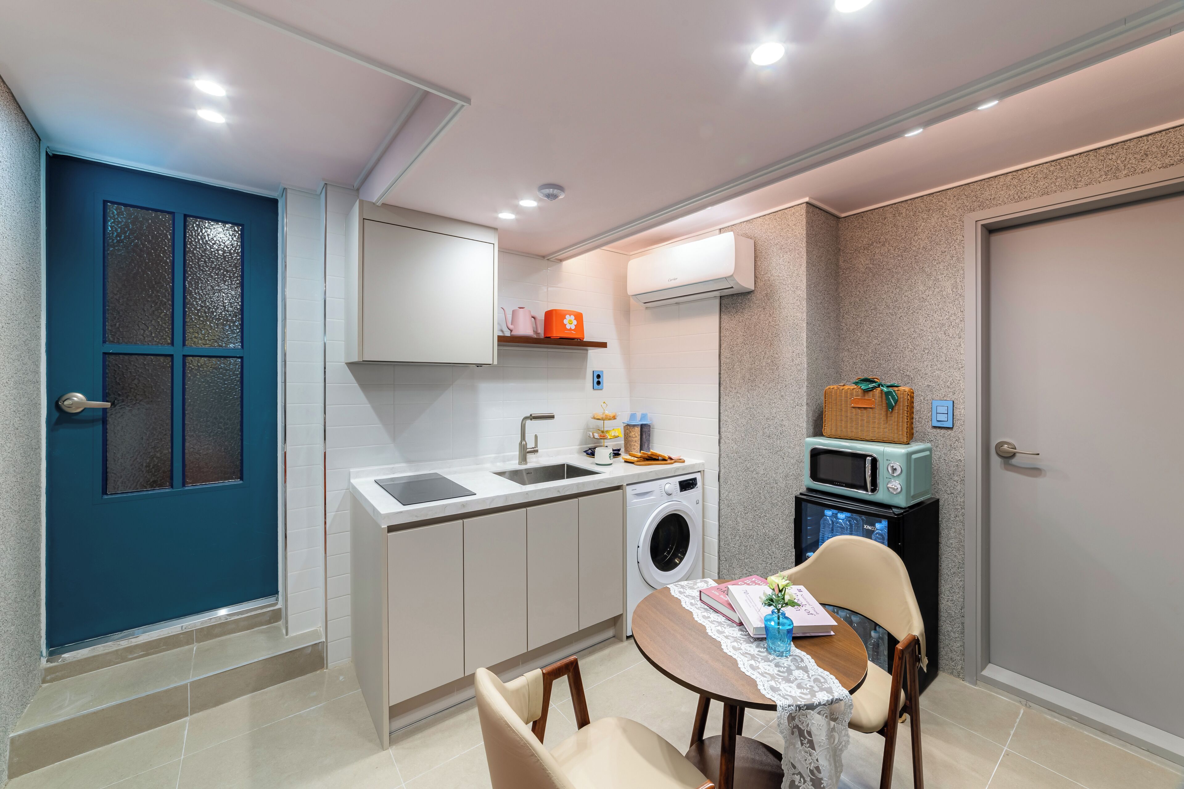A compact kitchen with a washing machine, a microwave, and a sink.