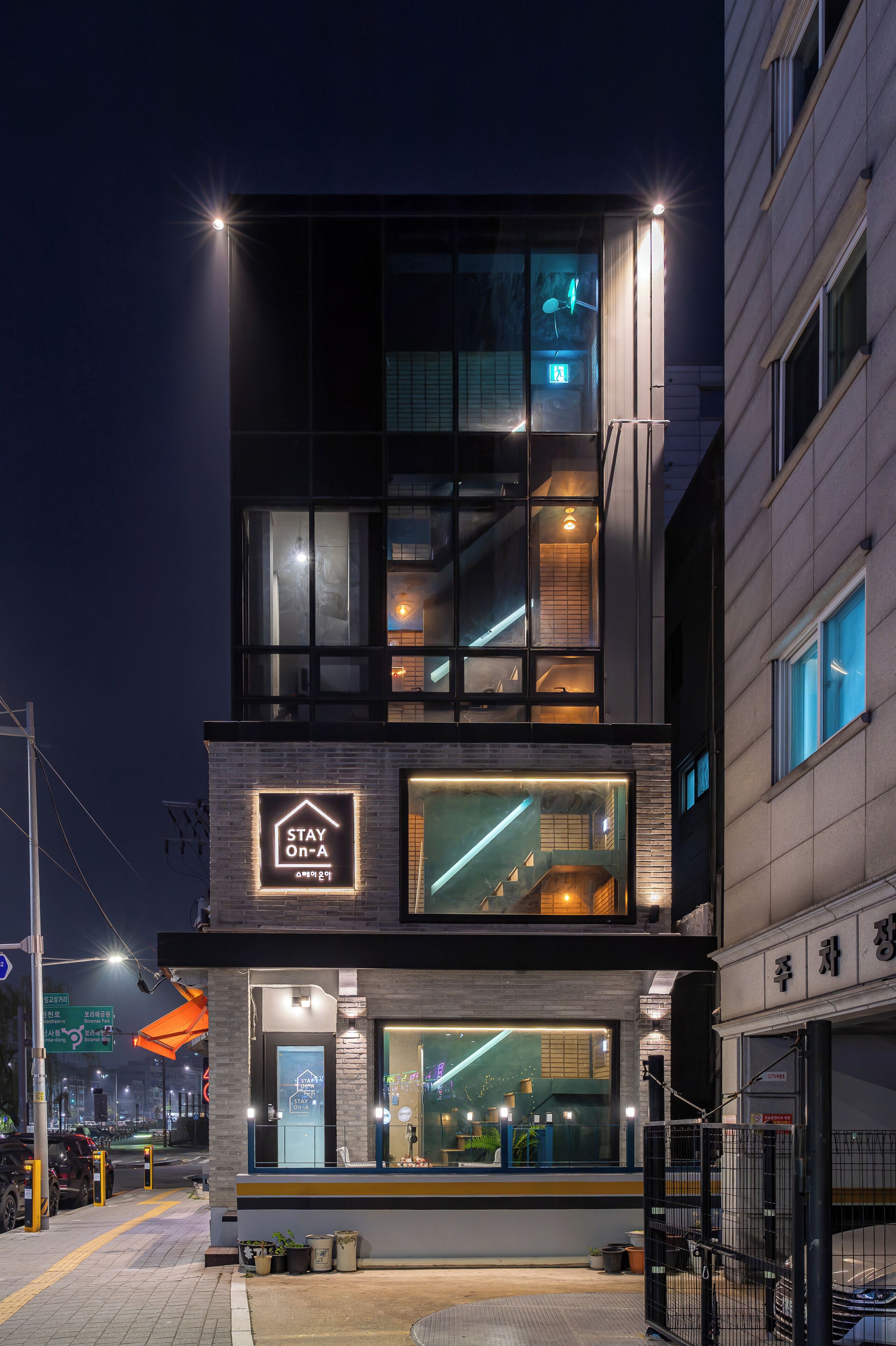 A modern building with a 'Stay On-A' sign, large windows, and a visible entrance.