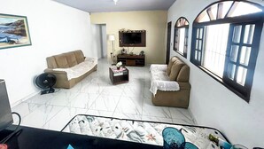 A living room with two sofas, a coffee table, a TV, and a window with a view.