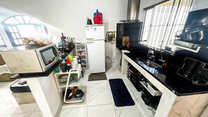 A compact kitchen with a refrigerator, microwave, and stove.