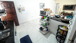 A compact kitchen with a microwave, sink, and a small dining area.
