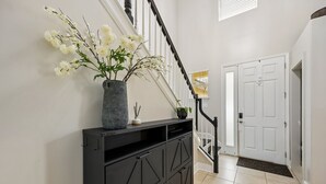 Eine Treppe mit einem schwarzen Beistelltisch und einer Vase mit weißen Blumen.