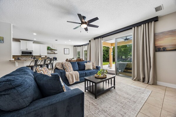 A modern living room with a sofa, coffee table, and a ceiling fan.