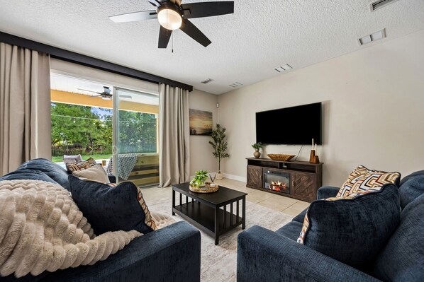 A living room with a sofa, coffee table, TV, and a fireplace.