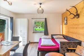 A modern room with a bed, a desk, and a view of the outdoors. - Apartment "Ferienwohnung Schulerhof" with Mountain View, Balcony and Wi-Fi (Oberau)